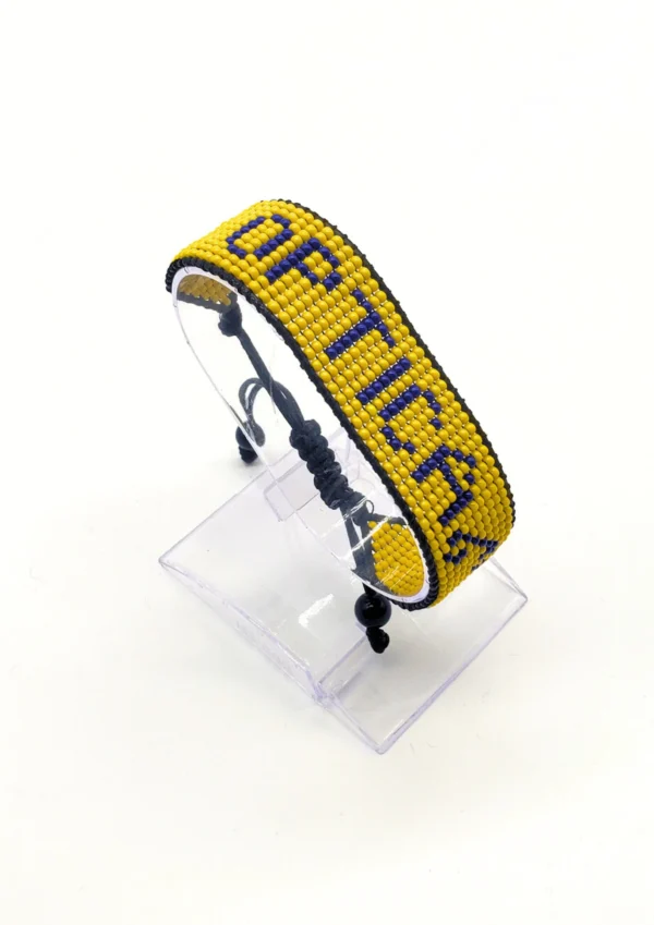 Adimu Flag bracelet handcrafted in authentic Corporate colors on Clear Stand.